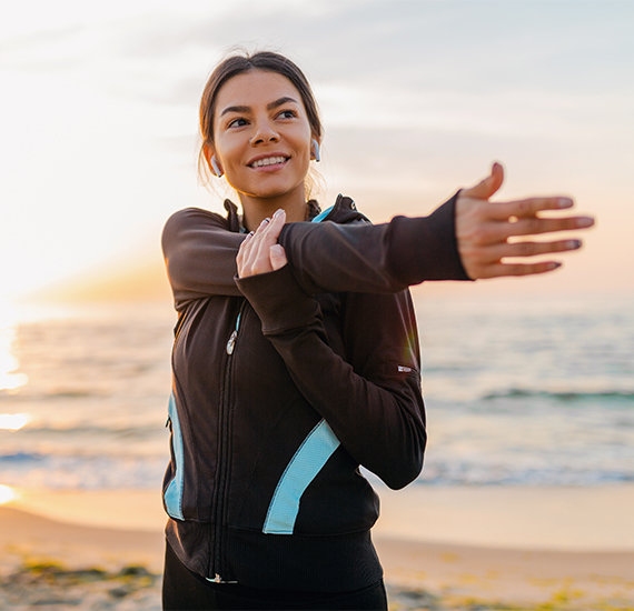 Weight loss program after photo of woman stretching on a beach after obtaining lasting weight loss results from Cook's pharmacy weight loss protocol.